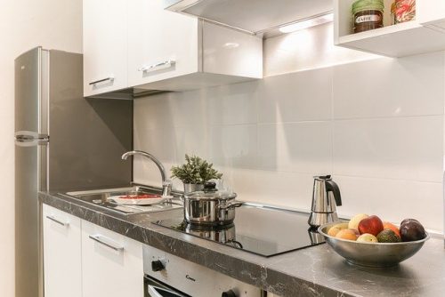 Dapur kecil minimalis berwarna putih dengan top table granit hitam